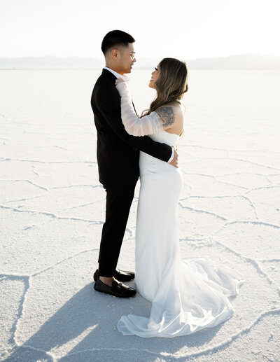 Couple looking into each others eyes holding each tother at the Salt Flats Utah in Wedding clothes