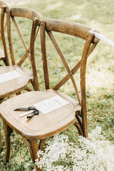 Sophisticated black and white fan-shaped wedding ceremony programs with black ribbon placed on wooden chairs at Ashford Acres Inn, Cynthiana, KY.