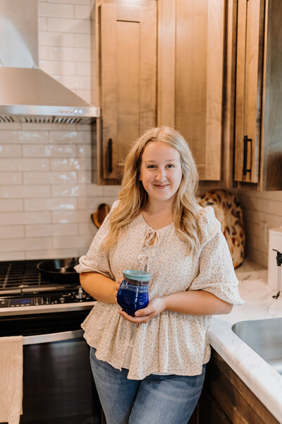 Kenna holding a cup of tea as she stands in the kitchen