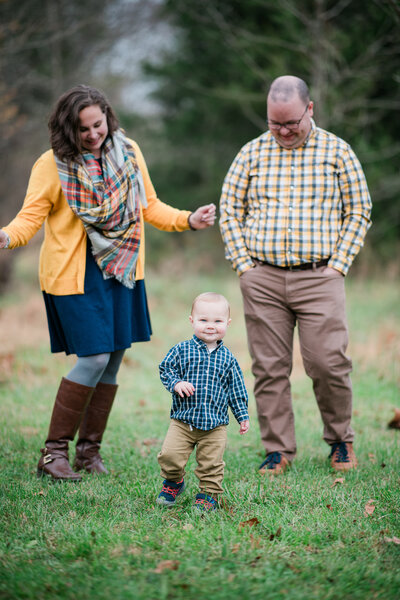 A young family poses for a heartwarming portrait with their child at Manassas Battlefield Park, captured by Nathan Sottung Photography.
