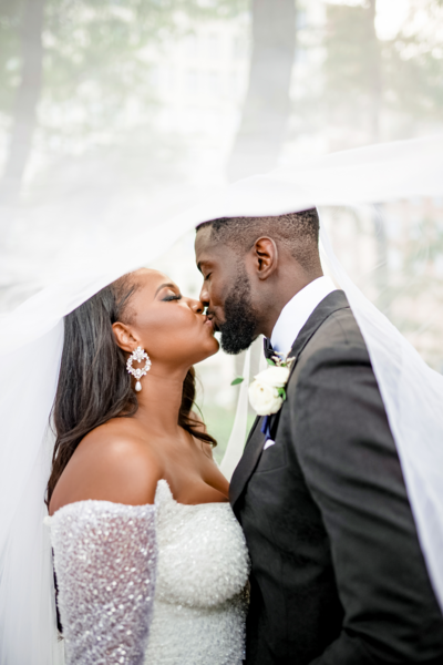 bride and groom share a kiss under the bride's veil