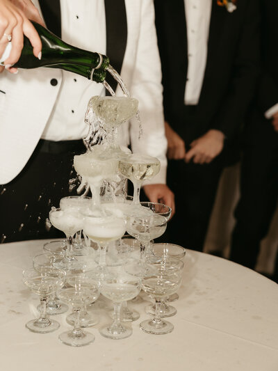 A champagne tower where the bride and groom are pouring a fresh toast for their guests. Photo by Dash and Boheme Photography. 