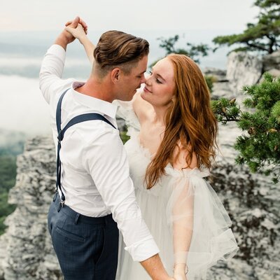 Newly engaged couple kissing on the cheek at the Mint Museum Charlotte Wedding Venue captured by Charlotte wedding photographer.