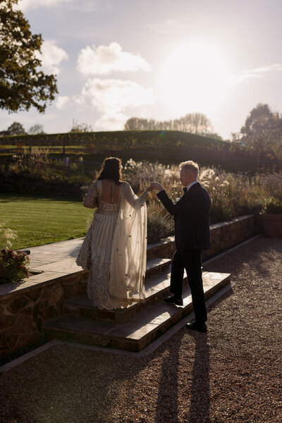 Wedding photographer captures couple taking a stroll hand in hand at their french chateau wedding.