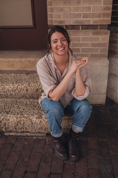 Photo of Marisa of Msav Creative Co sitting on the floor and smiling at the camera