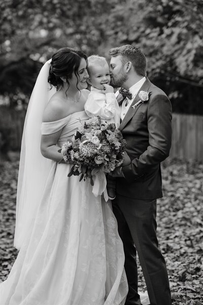 Timeless black and white wedding photography captures loving couple embracing their son at Gum Gully Farm.