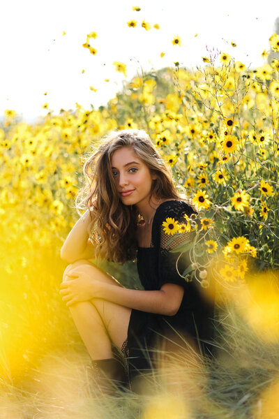 Beautiful senior girl in a sunny field of wildflowers in Colorado
