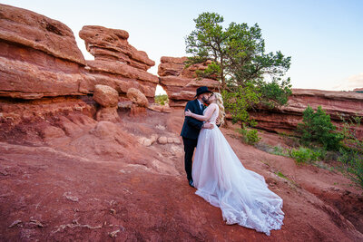Bride and groom kissing in front of red rock formations at Garden of the Gods during their Colorado Springs elopement.