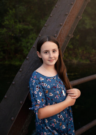Young girl on bridge looking at camera.