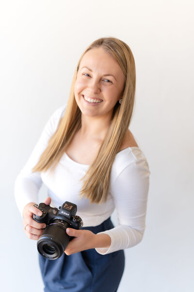Photographer smiling while holding her camera