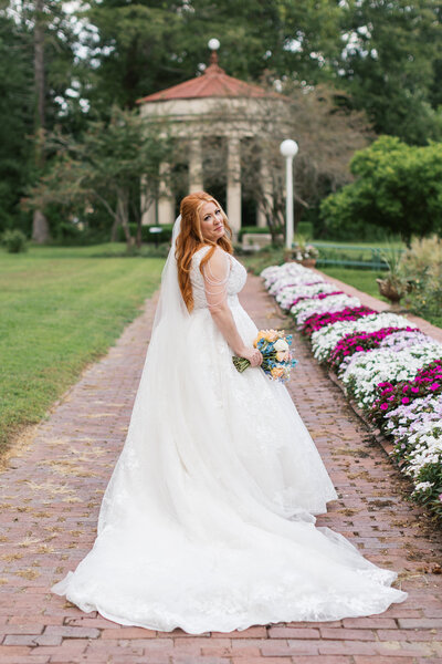 A bride looking over her shoulder laughing at the camera during her bridal photos. 