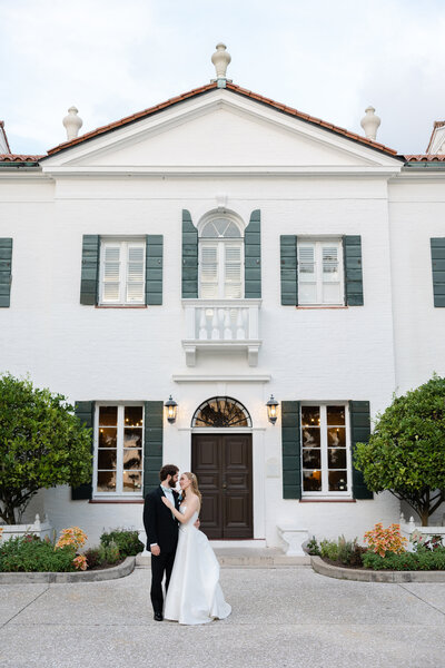 bride and groom standing in front of crane cottage in jekyll island resort