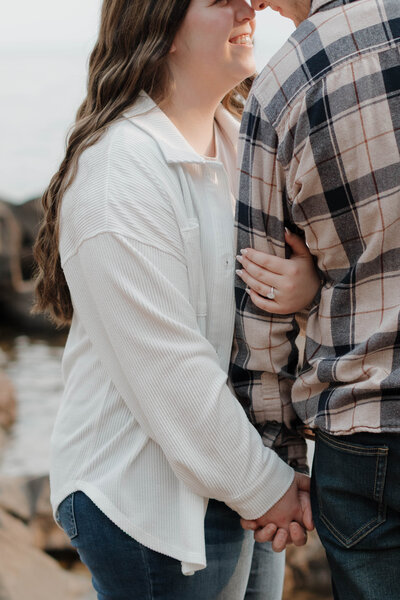 A person with their arm wrapped around their partner's as they lean in to kiss 