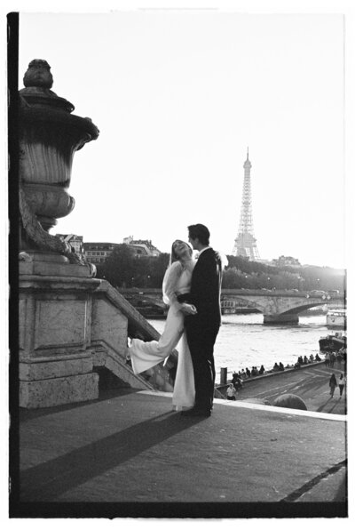 bride and groom laughing with eiffel tower behind them