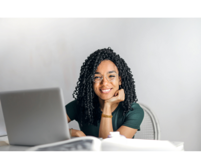 Woman sitting in front of a computer smiling at the camera