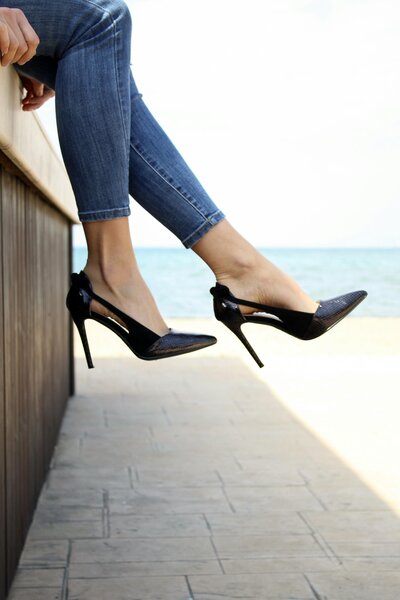 Woman in jeans and high heels by the water