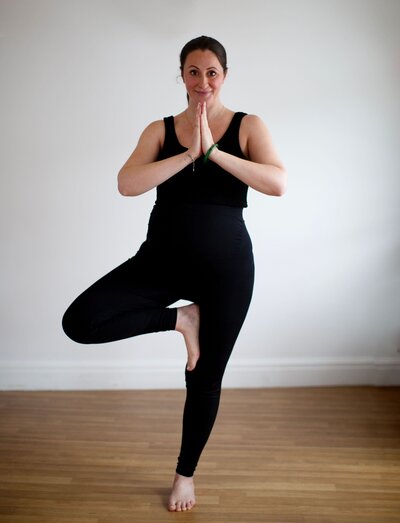 Mariella doing tree pose in a yoga studio
