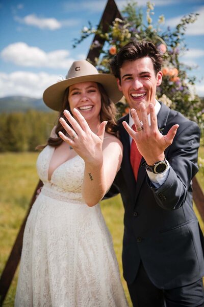 A happy couple celebrates their wedding beneath a blue sky in Whitefish, Montana.
