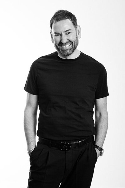 Salon owner dressed in black, showcasing professional leadership and expertise in hairdressing and styling services.