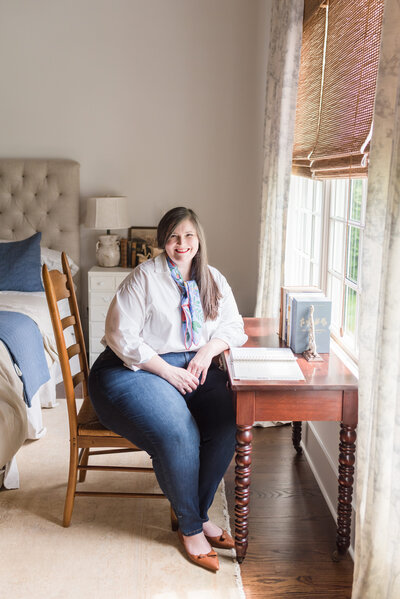 Lauren sits at her breakfast nook table in blue and white striped dress