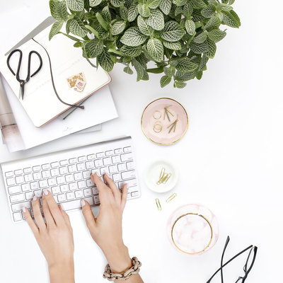 Image of hands typing at a desk on a keyboard