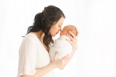mom holding newborn baby taken by Newborn photographer Boston
