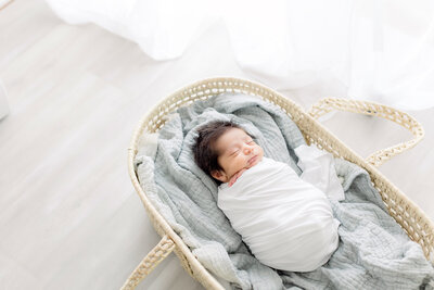 baby boy in moses basket for newborn pictures