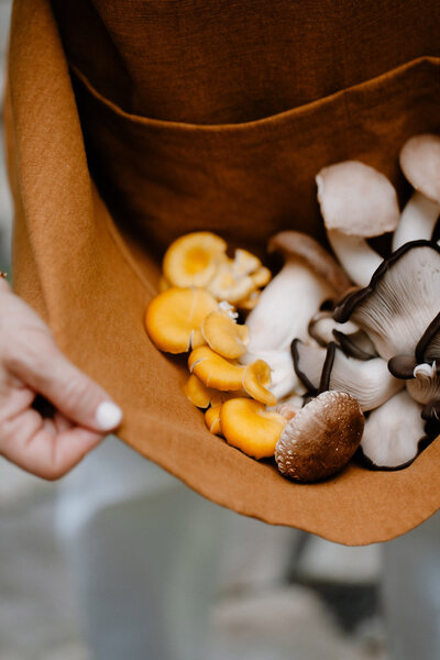 Sam holding an apron full of mushrooms