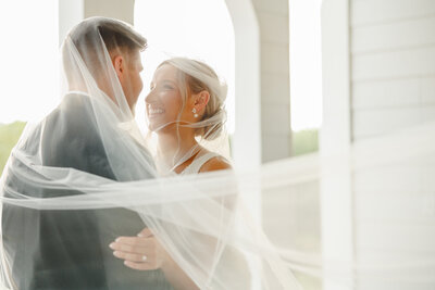 A groom kissing his bride on the forehead.