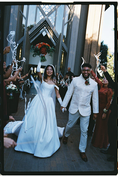 A joyful couple reviewing their wedding album together, capturing the satisfaction and cherished memories preserved through Ember's lens, as echoed in client testimonials.