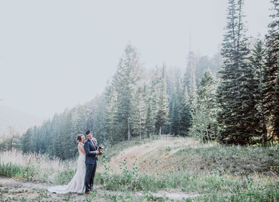 intimate Teton wedding with bride and groom embracing each other in the woods of the mountains