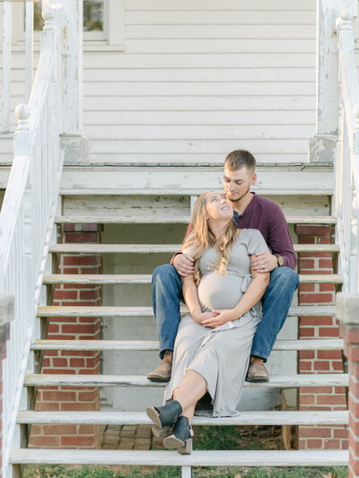 Expecting parents sitting on porch steps of Historical home in Richmond VA.