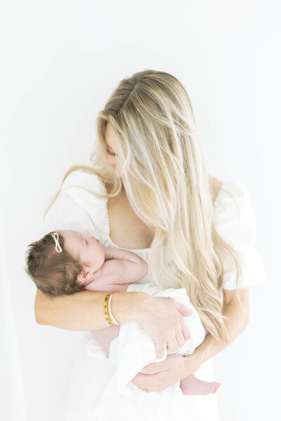 MOTHERHOOD IMAGE OF MOM HOLDING NEWBORN BABY STUDIO PHOTOGRAPHY BY MORGAN WORLEY