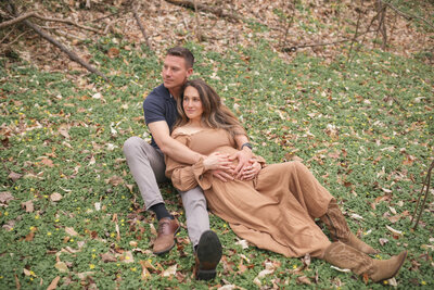 Pregnant couple embracing in field