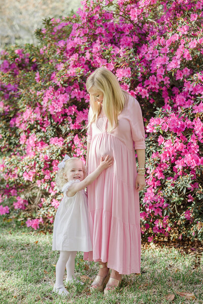 Toddler reaching up to touch her pregnant mothers belly -Maternity Photographer Greenville SC