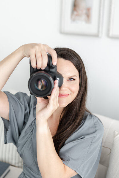 Connecticut photographer, Kristin Wood, smiles while taking a portrait with her camera