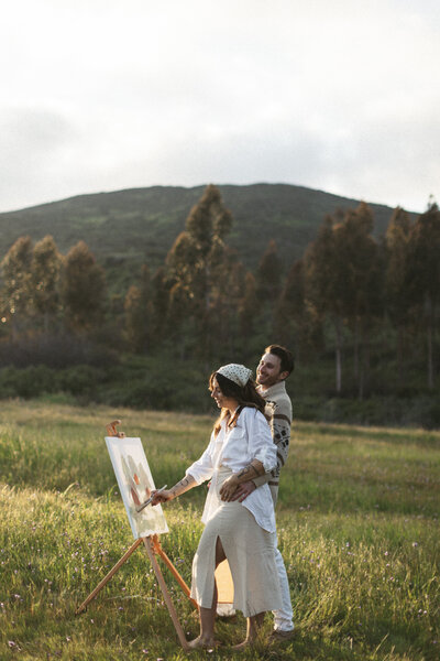 couple painting in a field