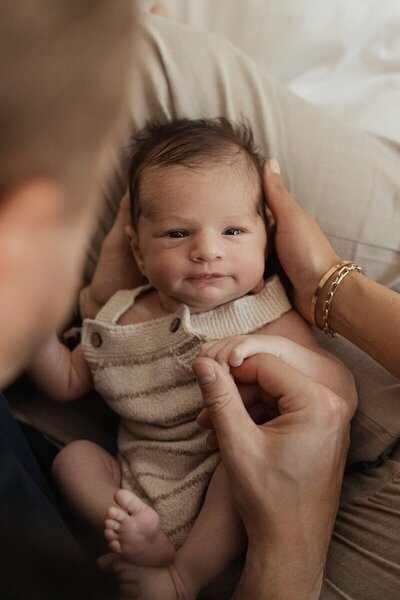 Close-up of newborn swaddled and smiling by Michigan photographers