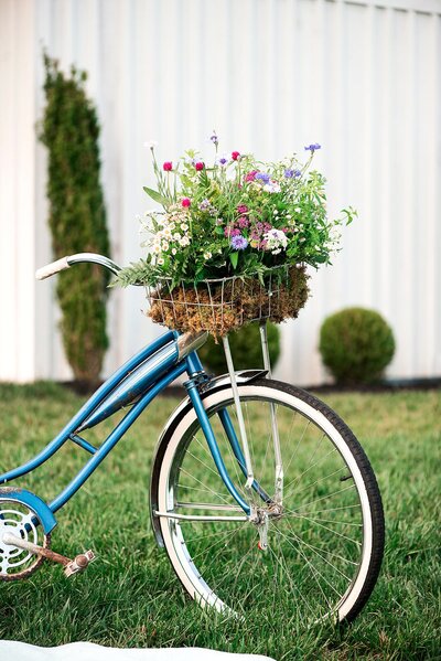 Blue bicycle with a basket full of wildflowers