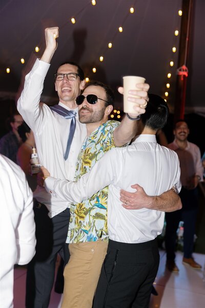 Wedding guests dancing and hugging at a reception 