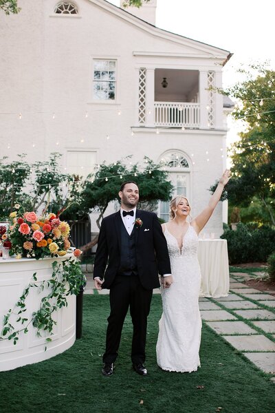 Bride holding colorful bouquet for portrait with groom.