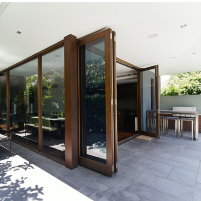 Modern style home with large glass folding patio doors the connects the in and outdoor living style allowing for fresh airflow and more natural light.
