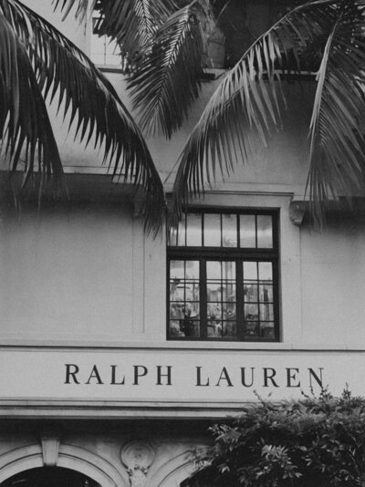 Black and white photo of the Ralph Lauren logo displayed above the storefront, embodying classic sophistication and luxury.