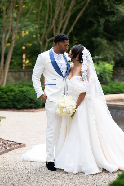 A bride and groom gaze at each other standing in the garden at the Atlanta History Center in Atlanta, GA