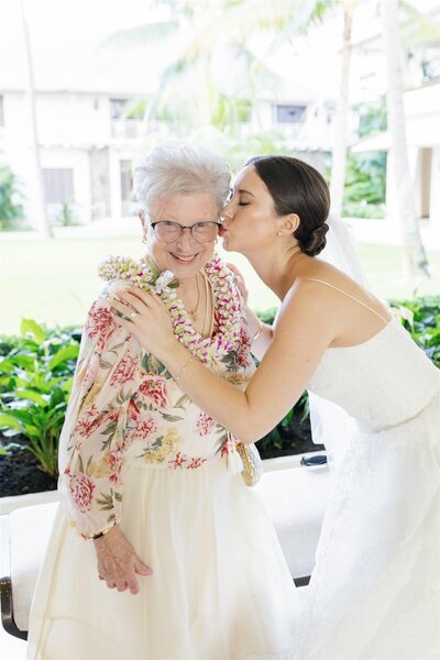 A newlywed kissing their grandparent's cheek 