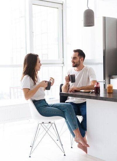 A couple sit and talk while holding coffee mugs. They appear to be having a pleasant conversation about something during their journey to affair recovery in Florida and beyond.  This could symbolize a couple trying to reconnect after experiencing an infidelity. We offer support with infidelity recovery in Florida. Contact Idit Sharoni for support recovering from an affair.
