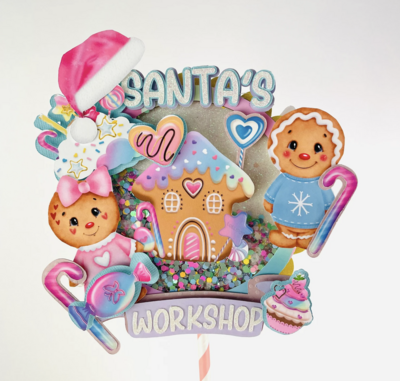Santa's workshop cake topper with pink candy and gingerbread men