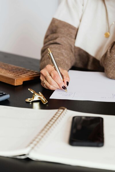 woman writing strategy for blog optimizations on paper