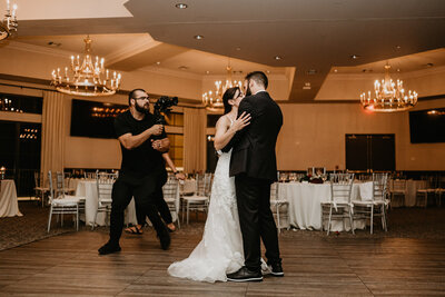 videographer filming bride and groom dancing