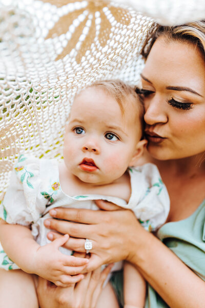 Mommy giving her baby kisses during their photoshoot in Baton Rouge